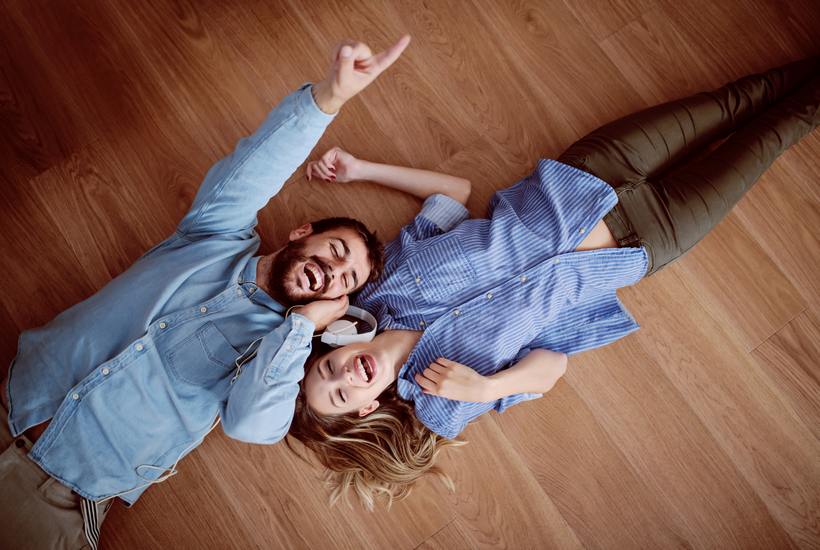 Top View Of Attractive Caucasian Couple Lying On The Floor Listening Music Over The