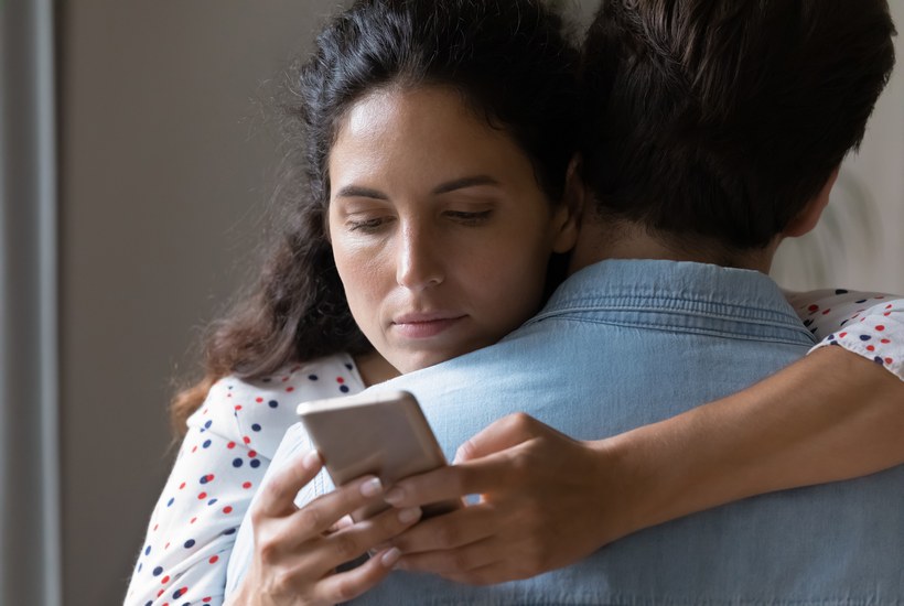 Young Woman Hug Husband Cheating Online On Cellphone