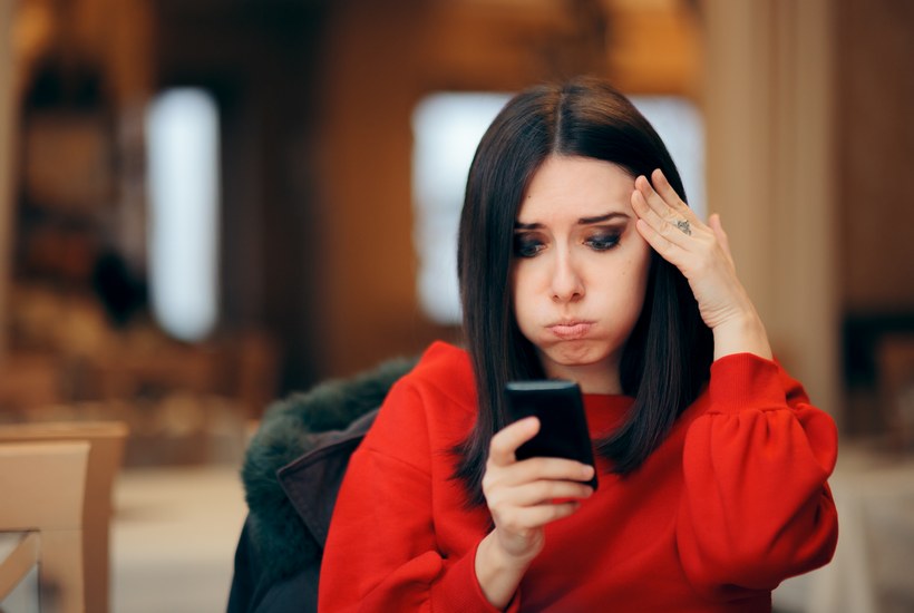 Stressed Woman Reading Text Message On Smartphone